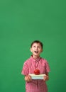 Surprised, mischievous boy holds books and an Apple in his hands and looks up Royalty Free Stock Photo