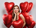 Surprised model woman with red balloons on white background. Cheerful girl with red lips makeup smiling and looking up. Surprise, Royalty Free Stock Photo