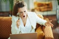 Surprised modern woman with laptop and magnifying glass Royalty Free Stock Photo