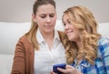 Surprised mother when looking phone of daughter