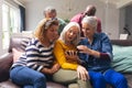 Surprised multiracial senior female friends looking at smart phone while men peeking from behind Royalty Free Stock Photo
