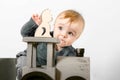 Surprised one year old child in a gray sweater plays wooden toys. Blonde baby boy on white background. Close up Royalty Free Stock Photo