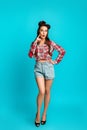 Surprised pinup woman in retro style clothes cannot believe great offer or huge sale over blue studio background