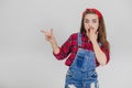 Surprised pretty girl covering her widely opened mouth with hand, pointing her finger to the side. Royalty Free Stock Photo