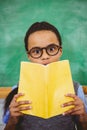 Surprised pupil holding school book