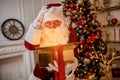 Surprised Santa Claus with a magical glowing gift near beautiful christmas tree. New year and Merry Christmas , happy holidays