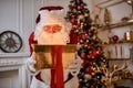 Surprised Santa Claus with a magical glowing gift near beautiful christmas tree. New year and Merry Christmas , happy holidays