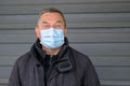 Surprised or sceptical middle-aged man wearing a face mask