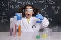 Surprised scientist child in lab coat with flasks