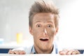 Surprised scientist looking out behind table after experiment in lab