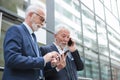 Surprised senior businessman talking on the phone in front of an office building Royalty Free Stock Photo