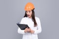 Surprised shocked excited business woman with clipboard on gray background. Portrait of female builder worker in hardhat Royalty Free Stock Photo