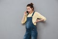 Surprised shocked pregnant woman standing and talking on mobile phone Royalty Free Stock Photo