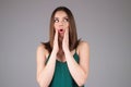 Surprised shocked young girl isolated over gray studio background. Close up shot of emotive shocked young woman opens