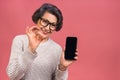 Surprised smiling happy senior mature aged senior woman in casual showing blank smartphone screen while looking at the camera Royalty Free Stock Photo