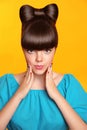 Surprised smiling teen girl with bow hairstyle, makeup and colourful manicured nails. Funny brunette in blue dress showing Royalty Free Stock Photo