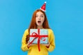 Surprised startled pretty redhead girl receive unexpected gift for christmas classmate, open mouth astonished and