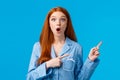 Surprised startled redhead girl found out special offer, discount promo, pointing upper right corner, wearing nightwear