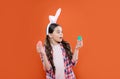 surprised teen girl in funny bunny ears for easter holiday hold eggs, egg hunt Royalty Free Stock Photo