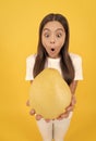 surprised teen girl hold fruit of yellow pomelo full of vitamin, selective focus, big fruit.