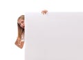 Surprised teen girl is popping out from the side of white blank banner,isolated Royalty Free Stock Photo