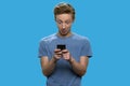 Surprised teenage boy using mobile phone Royalty Free Stock Photo