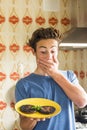 Surprised teenager after brned two hamburger cooked in the kitchen at home - young boy do chef and mistakes.- funny people real