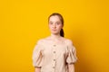 Surprised teenager girl. Studio image of a cute surprised  young girl on yellow background Royalty Free Stock Photo