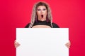 Surprised transgender person holding a blank panel in studio