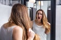 Surprised unhappy young woman checking her dry tousled long hair