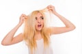 Surprised unhappy young woman looking at her damaged hair Royalty Free Stock Photo