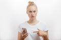 Surprised upset young blonde woman with her smart phone Royalty Free Stock Photo