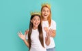 Surprised wide-eyed selfish woman mother and daughter child wear crowns blue background, surprise Royalty Free Stock Photo