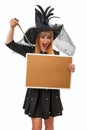 Surprised witch holding a blank cork board and pointing her magic wand at it with her mouth open Royalty Free Stock Photo