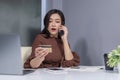 surprised woman calling by phone and holdind credit card to online shopping Royalty Free Stock Photo