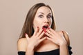 Surprised woman covers open mouth with fingers