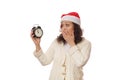 Surprised woman expresses astonishment stupefaction, looking at retro black alarm clock showing midnight. Happy New Year