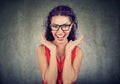 Surprised woman in glasses over gray background