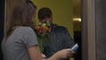 Surprised woman opens door and meets flower deliverer