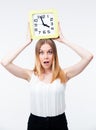 Surprised woman holding big clock Royalty Free Stock Photo