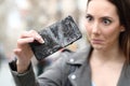 Surprised woman looking at her broken smart phone Royalty Free Stock Photo