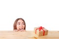 Surprised woman looks at a gift box. Christmas, x-mas, winter, happiness concept. Royalty Free Stock Photo