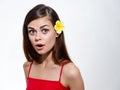 surprised woman with open mouth and yellow flower in her hair red t-shirt portrait Royalty Free Stock Photo