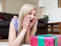 Surprised woman opening gifts lying on the floor Royalty Free Stock Photo