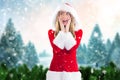 Surprised woman in santa costume standing against digitally generated background Royalty Free Stock Photo