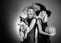 Surprised woman in witches hat and costume on red Halloween background. Attractive model girls in Halloween costume