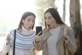 Surprised women checking phone in a foggy park