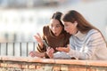 Surprised women in winter listening to music on phone