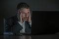 Young desperate and stressed businessman working overtime at office laptop computer desk feeling anxious and overwhelmed suffering Royalty Free Stock Photo