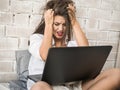 Surprised worried woman looking in screen of laptop computer getting bad information Royalty Free Stock Photo